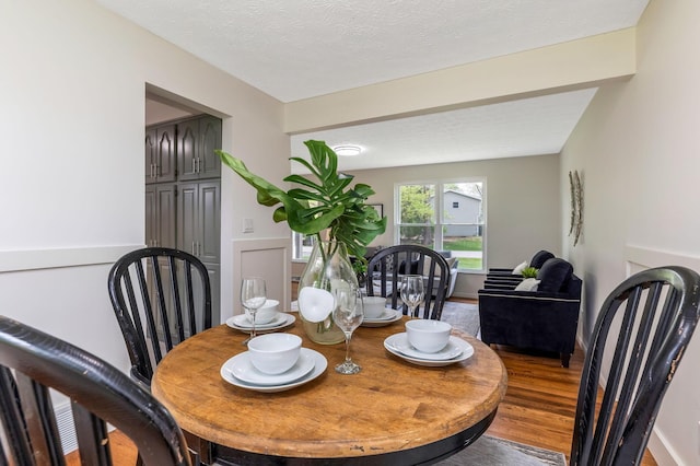 dining space with a textured ceiling and wood finished floors