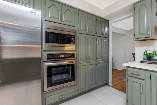 kitchen featuring light countertops, green cabinetry, and appliances with stainless steel finishes