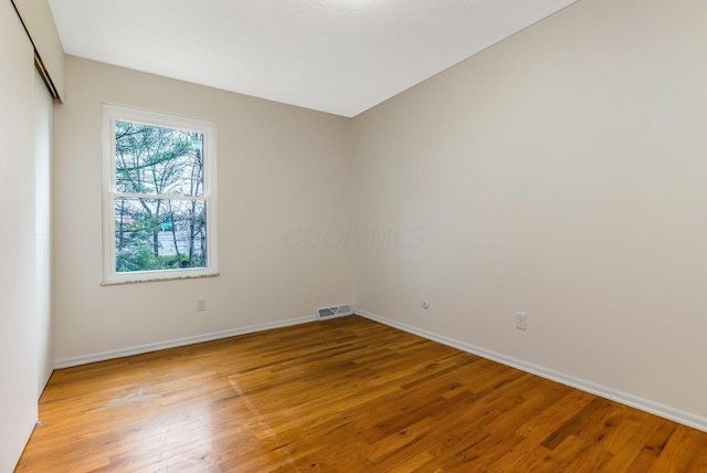spare room featuring baseboards and light wood-style flooring