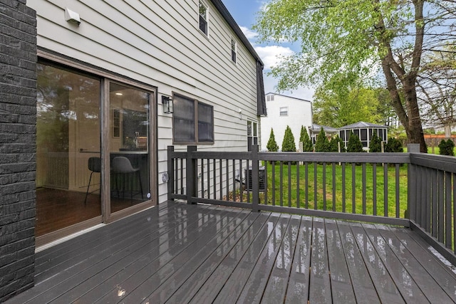 wooden terrace with central air condition unit and a lawn
