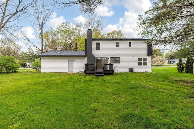 rear view of property featuring a lawn, a chimney, and a deck