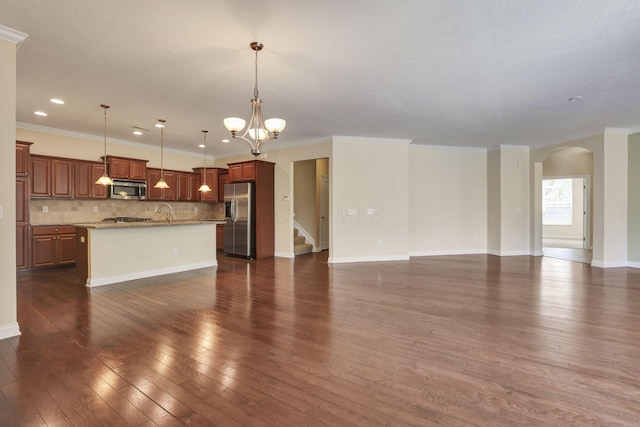 unfurnished living room featuring dark wood-style flooring, arched walkways, a chandelier, and ornamental molding