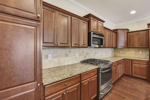 kitchen featuring decorative backsplash, appliances with stainless steel finishes, ornamental molding, and light stone counters