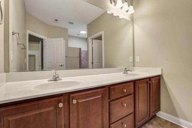 bathroom with double vanity, visible vents, and a sink