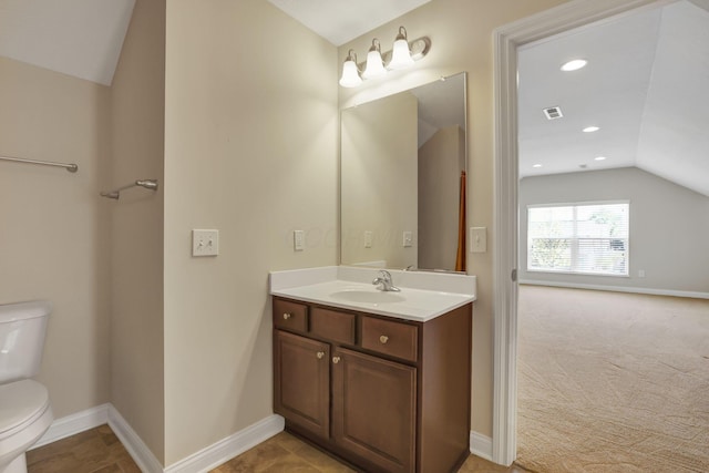 bathroom with toilet, baseboards, vaulted ceiling, and vanity