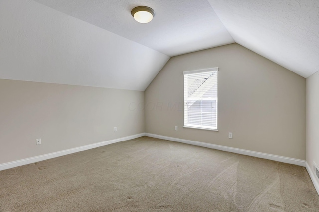 bonus room with vaulted ceiling, baseboards, carpet flooring, and a textured ceiling