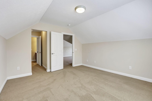 additional living space with baseboards, carpet, and lofted ceiling