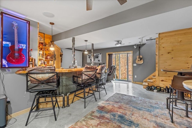 bar featuring indoor wet bar, stairs, and finished concrete flooring