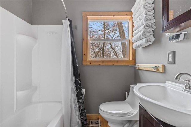 bathroom with shower / bath combo, vanity, toilet, baseboards, and visible vents