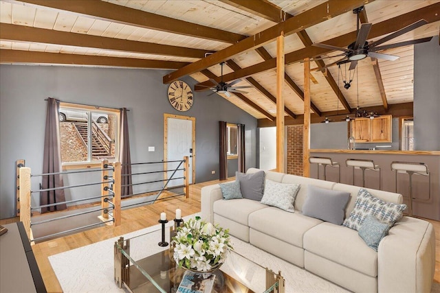 living area with a ceiling fan, wood ceiling, and wood finished floors