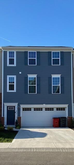 multi unit property with concrete driveway, a garage, and brick siding