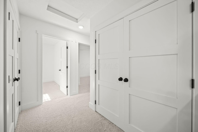 hallway with baseboards, carpet, attic access, and recessed lighting