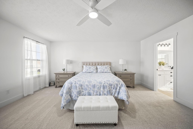 bedroom featuring light carpet, ensuite bath, a textured ceiling, a ceiling fan, and baseboards
