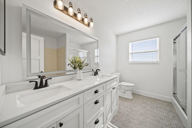 bathroom with a sink, a stall shower, and double vanity