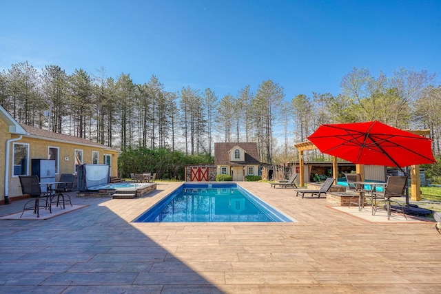 pool with an outdoor structure, a wooden deck, a jacuzzi, and a storage structure