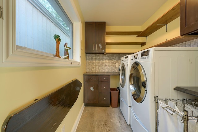 laundry area featuring separate washer and dryer, baseboards, and cabinet space
