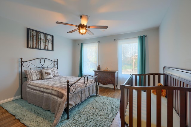 bedroom with baseboards, ceiling fan, and wood finished floors