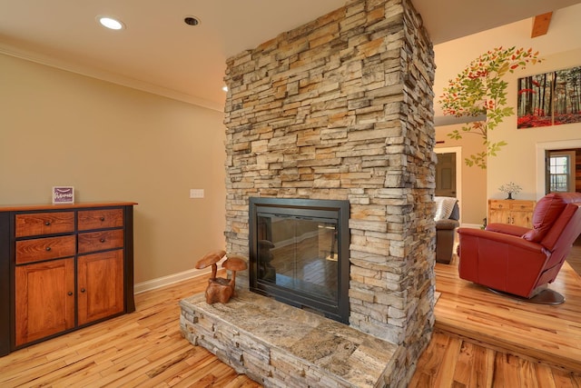 living area with crown molding, a fireplace, light wood-style floors, recessed lighting, and baseboards