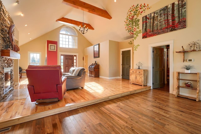 living area with a notable chandelier, beam ceiling, high vaulted ceiling, hardwood / wood-style floors, and visible vents