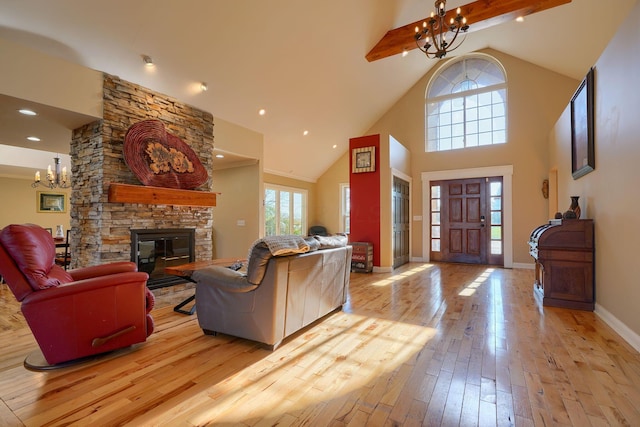 living room featuring a fireplace, high vaulted ceiling, beamed ceiling, wood-type flooring, and a notable chandelier