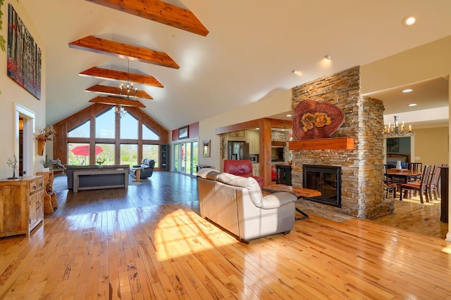 living room featuring an inviting chandelier, beam ceiling, a fireplace, high vaulted ceiling, and hardwood / wood-style flooring