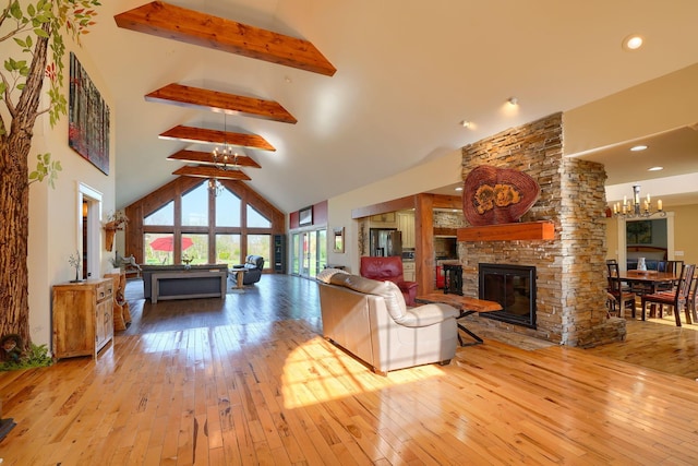 living area featuring a fireplace, high vaulted ceiling, beamed ceiling, an inviting chandelier, and hardwood / wood-style floors