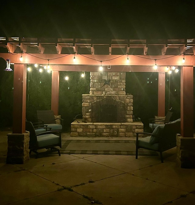 patio at twilight featuring a pergola and a fireplace