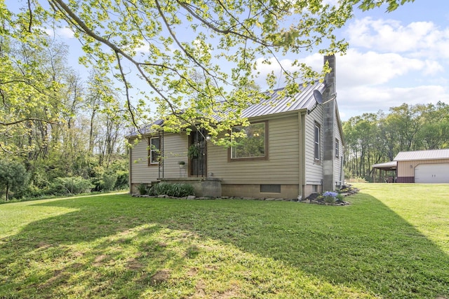 view of front of house with a standing seam roof, metal roof, a chimney, a front yard, and a garage