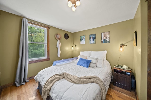 bedroom featuring baseboards and wood-type flooring