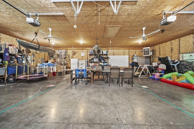 garage with a garage door opener, freestanding refrigerator, and a workshop area