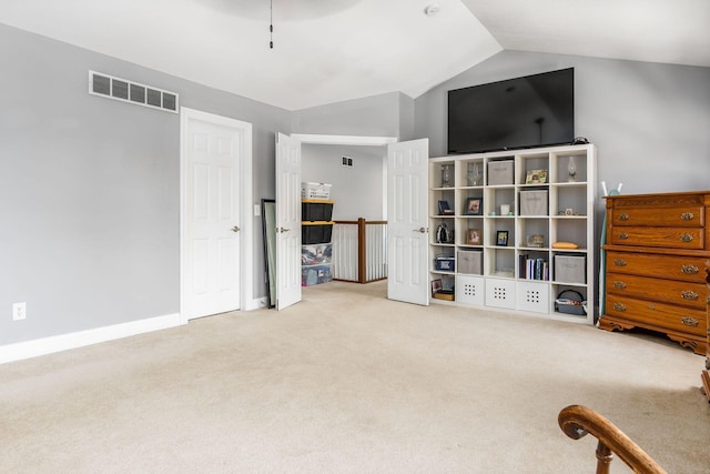 interior space with carpet flooring, baseboards, visible vents, and lofted ceiling