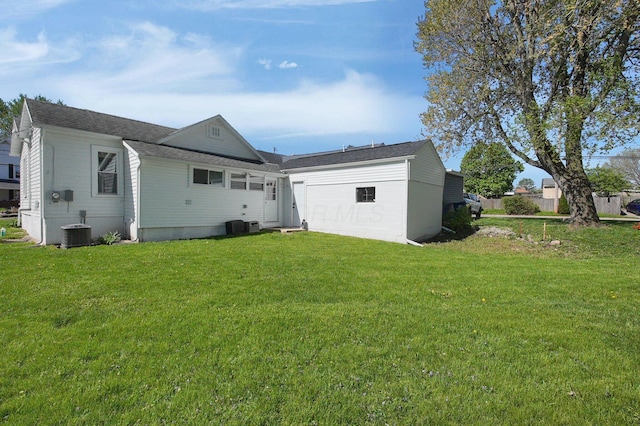 rear view of house featuring a lawn and central AC
