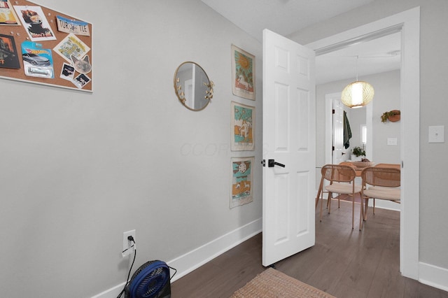 corridor with baseboards and dark wood-style floors