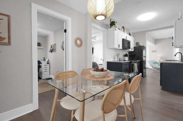 dining space with baseboards and dark wood finished floors
