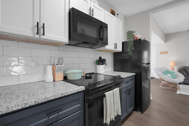 kitchen with backsplash, wood finished floors, black appliances, and light stone countertops