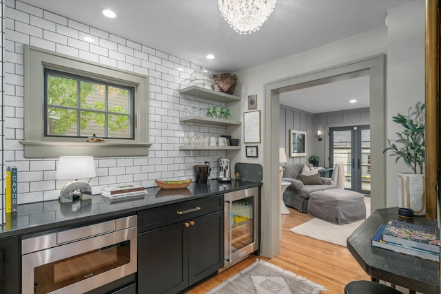 152 S Stanwood Rd, Columbus, OH 43209 - bar featuring light wood-style flooring, wine cooler, tasteful backsplash, and stainless steel microwave