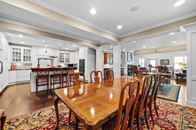 dining area with decorative columns, ornamental molding, dark wood-style flooring, and recessed lighting