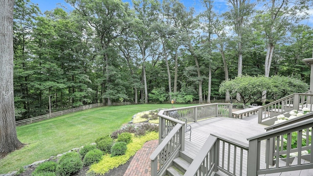 deck featuring a yard, fence, and stairs
