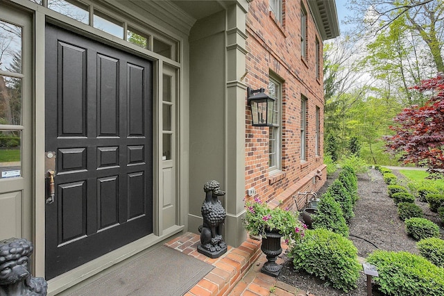 view of exterior entry featuring brick siding