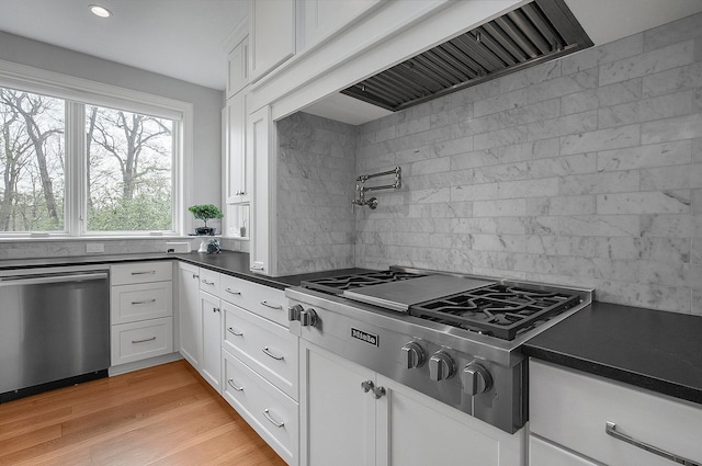 kitchen featuring decorative backsplash, dark countertops, appliances with stainless steel finishes, recessed lighting, and white cabinetry