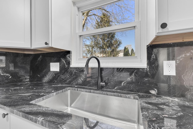 7847 Maplecreek Ct, Powell, OH 43065 - kitchen with white cabinets, decorative backsplash, a sink, and dark stone counters