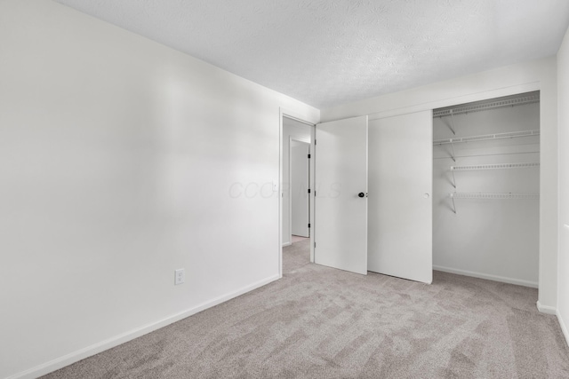 7847 Maplecreek Ct, Powell, OH 43065 - unfurnished bedroom featuring carpet floors, baseboards, a closet, and a textured ceiling