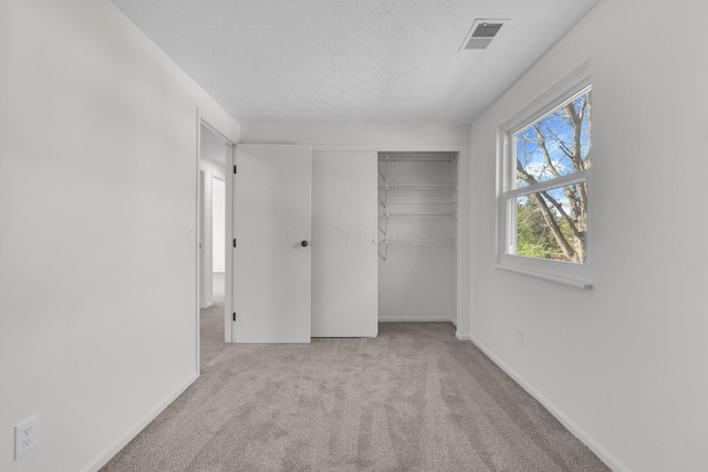 7847 Maplecreek Ct, Powell, OH 43065 - unfurnished bedroom featuring carpet floors, a textured ceiling, baseboards, visible vents, and a closet