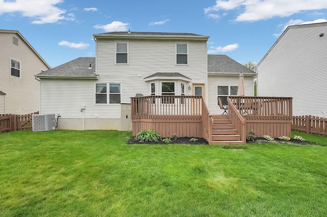 rear view of property featuring a lawn, a fenced backyard, and a wooden deck