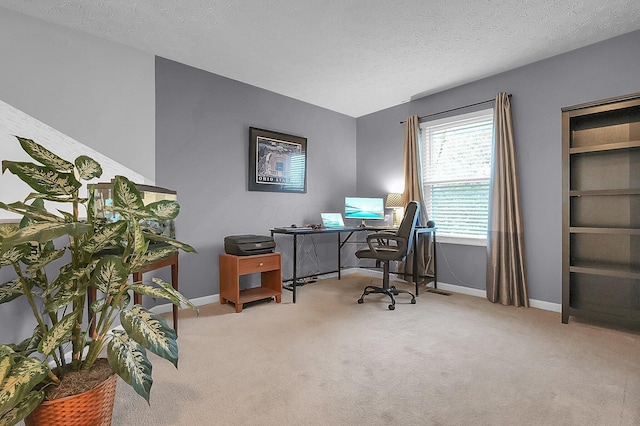 carpeted office with baseboards and a textured ceiling