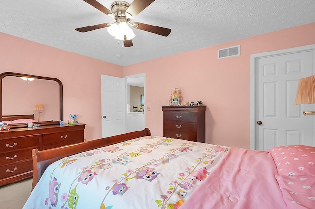 bedroom featuring visible vents, a textured ceiling, and ceiling fan