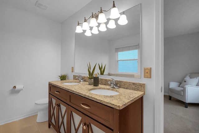 bathroom featuring double vanity, toilet, baseboards, and a sink