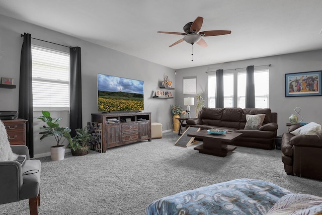 living room with carpet floors, baseboards, and a ceiling fan