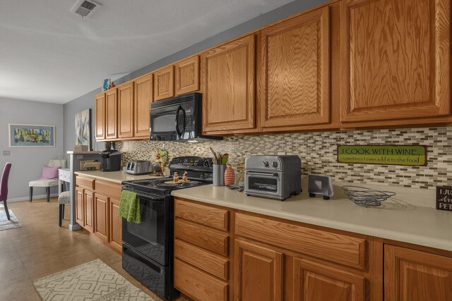 kitchen with visible vents, brown cabinetry, light countertops, backsplash, and black appliances