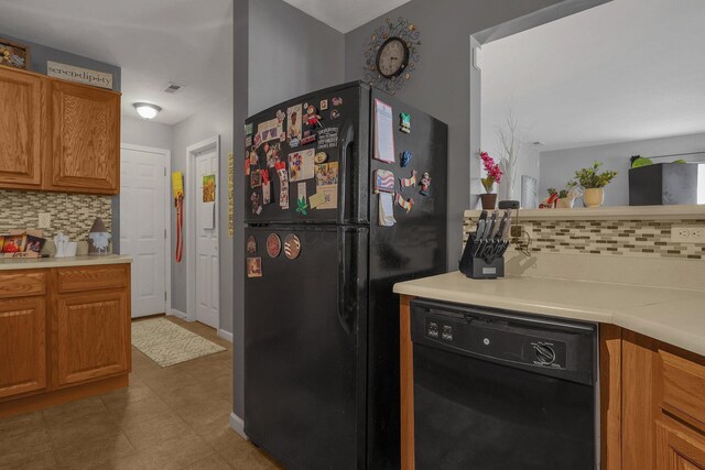 kitchen with light countertops, backsplash, black appliances, and brown cabinets